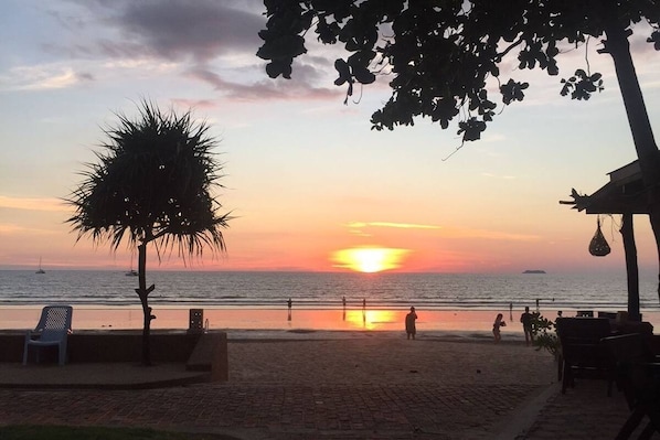 Solnedgang på strand med stole og parasoller ved Southern Lanta Resort