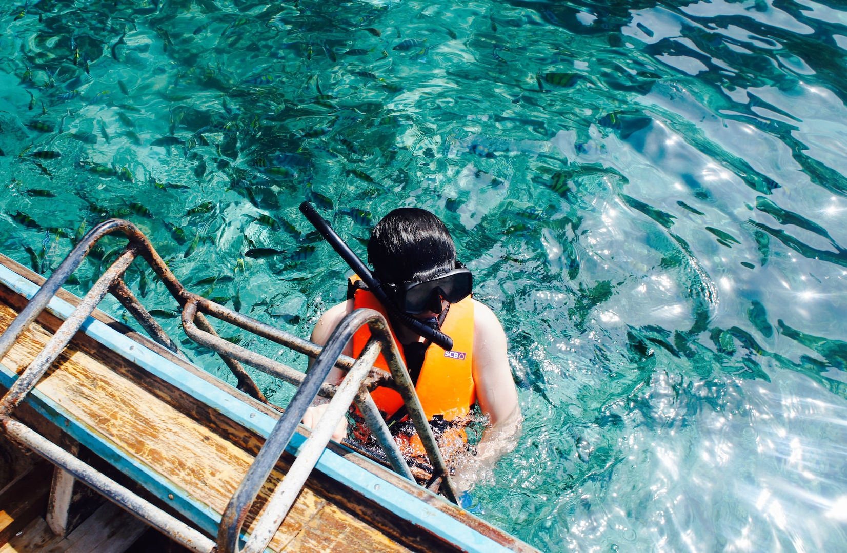 Familie snorkling i klart vand på en bådtur i Phuket, Thailand.