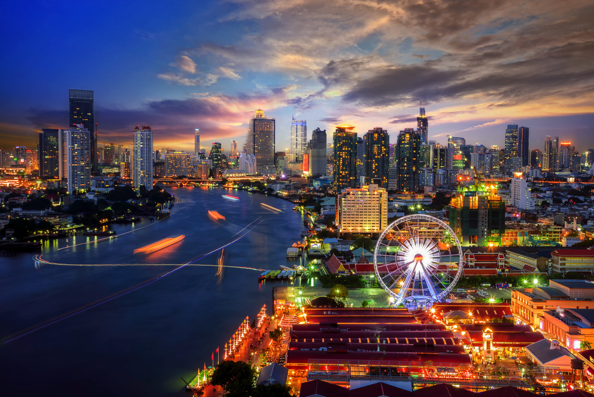Bangkok, Thailand ved skumring med et pariserhjul. Denne pulserende by kombinerer en spændende byferie-oplevelse med mulighed for at nyde