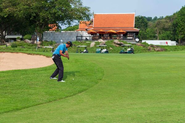 Mand spiller golf på Banyan Golf Club Hua Hin med sandbunker i baggrunden