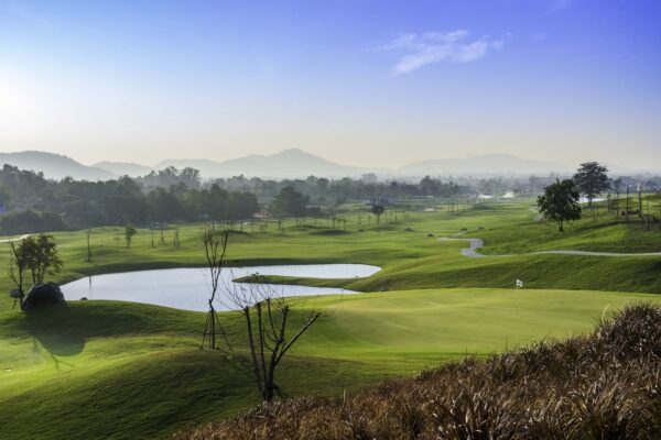 Find en smuk og fredfyldt golfbane på Black Mountain Golf Club i Hua Hin, der byder på idylliske damlandskaber og slående bjergudsigter.