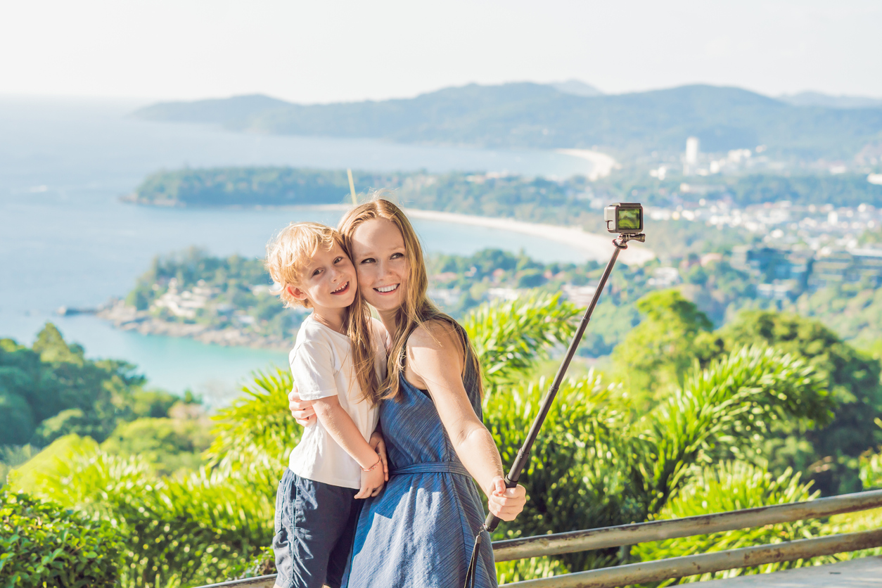 Kvinde og barn tager selfie med selfiestick på familieferie