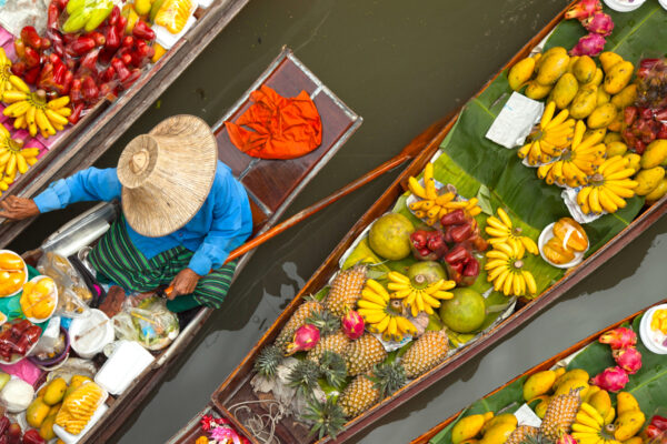 En mand tilbringer sin sin dag på en båd fyldt med forskellige friske frugter.