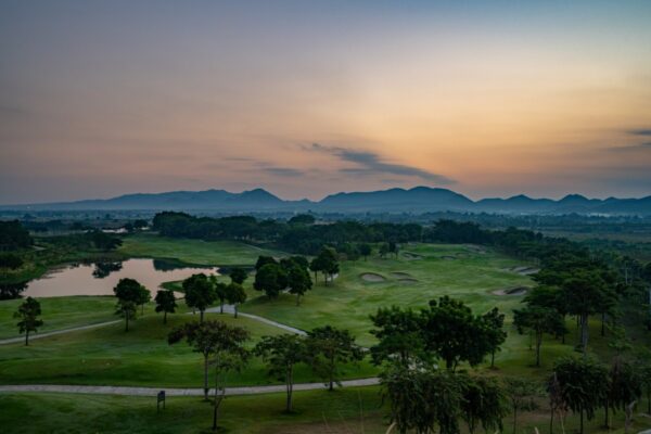  Grand Prix Golf Club i skumringen med bjerge i baggrunden, Kanchanaburi
