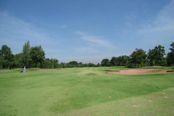 En velholdt golfbane i Bangkok kendt som Green Valley Country Club, med frodige grønne fairways pænt trimmet og sandbunker, der giver et