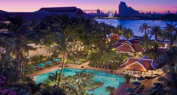 Anantara Bangkok Riverside Resort swimmingpooludsigt ved solnedgang, luksusferiebolig i Thailand.