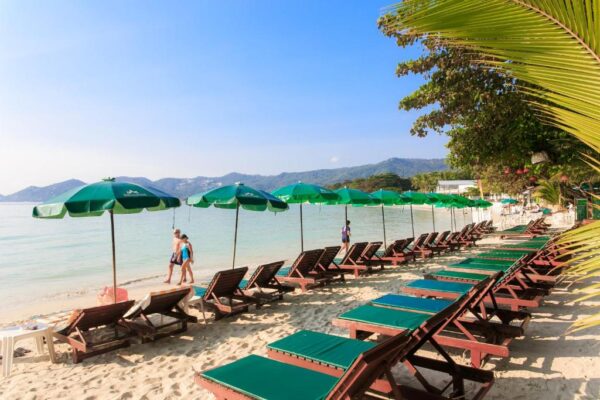 Slap af på Baan Chaweng Beach Resort med lounge stole, parasoller og palmetræer direkte ved stranden. Oplev det perfekte strandresort for