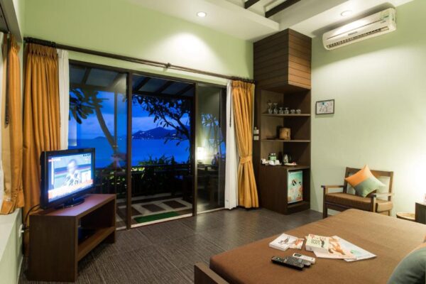 Værelse ved stranden med seng og tv på Baan Chaweng Beach Resort med udsigt over havet