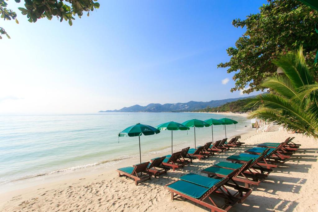 Hyggeligt strandresort med liggestole og parasoller på sandet - Baan Chaweng Beach Resort & Spa tilbyder en afslappende strandstemning i