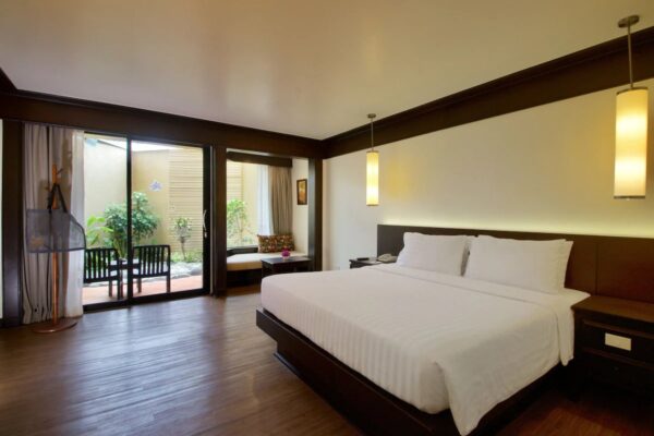 Rummeligt soveværelse med stor seng og trægulve på Beyond Resort Kata