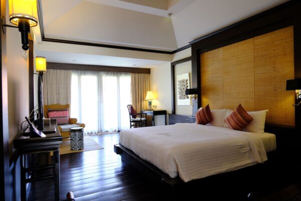 Hotelværelse med stor seng og trægulve på Bodhi Serene Hotel