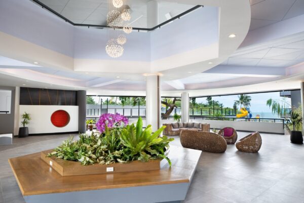 Billeder af Centara Cha-Am Beach Resort lobby dekoreret med planter og blomster.
