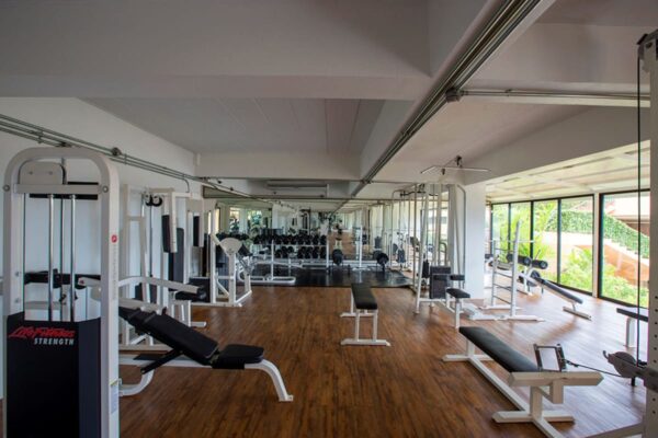 Rummeligt fitnesscenter med en række vægte og fitnessudstyr placeret i Chanalai.