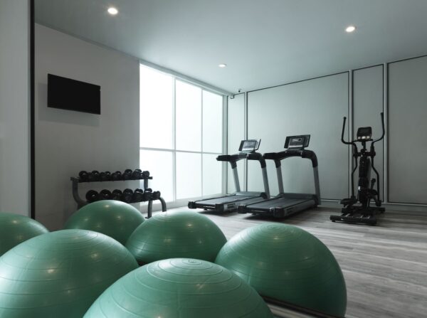 Resort gym med grønne træningsbolde og løbebånd