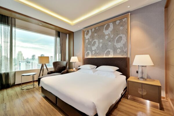 Stort seng i Sathorn hotelværelse med byudsigt