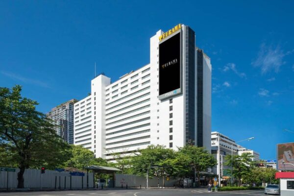 Hvidt Furama Silom Hotel Bangkok bygning med sort skilt