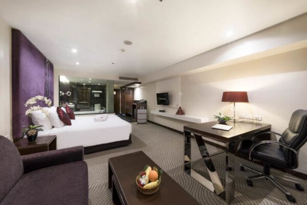 Hotelværelse på Furama med en seng, skrivebord og TV