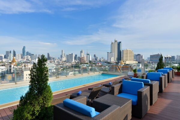 Poolhotel Kina på taget med udsigt over byen og blå stole