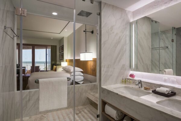 Billeder af badeværelse med stort spejl og glasbrusekabine på Hilton Hua Hin Resort - ideelt til en spa-agtig oplevelse
