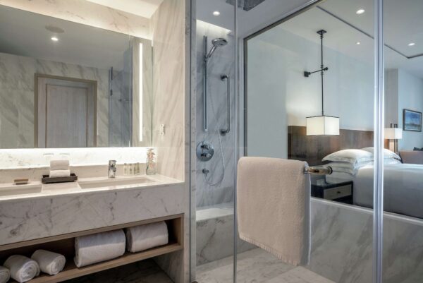 Marmorbadeværelse på Hilton Hua Hin Resort and Spa med stort spejl og komfortabel badeseng til et afslappende ophold.