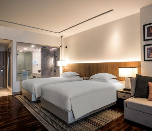 Moderne Hilton Hotel værelse med enkelte senge og komfortabel sofa