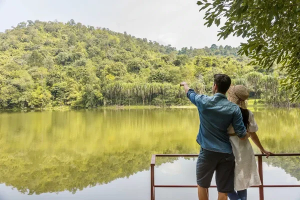 Par på ferie i Phutoey River Kwai Hotspring & Natur Resort, nyder roen ved søkanten