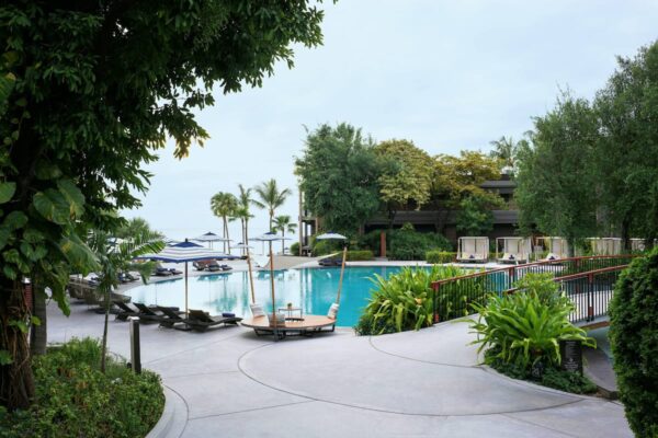 Hua Hin Marriott Resorts swimmingpoolområde omgivet af frodige grønne træer