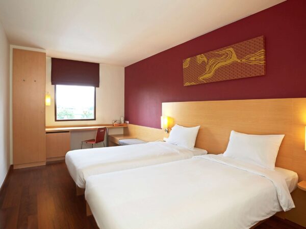 Hotelværelse med senge og skrivebord på Ibis Riverside i Bangkok