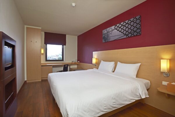 Hotelværelse med røde vægge på Ibis Bangkok Riverside med en behagelig seng