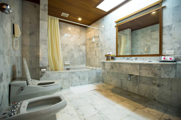 Klassisk badeværelse i kejserstil med vintage vask og rektangulært spejl. Elegant antikke armaturer i hvide toner, perfekt til traditionel