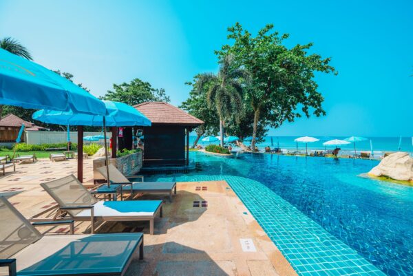 Resorts swimmingpool omgivet af liggestole og parasoller til en afslappende ferie