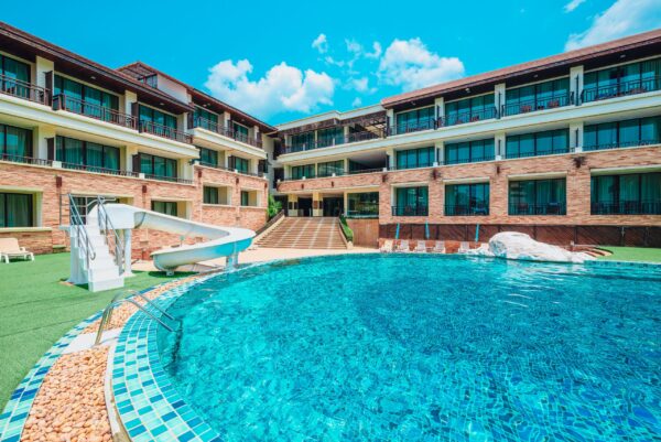 Swimmingpool på Kacha Resort hotel med liggestole og parasoller, tropiske omgivelser med palmer, stort poolområde perfekt til afslapning
