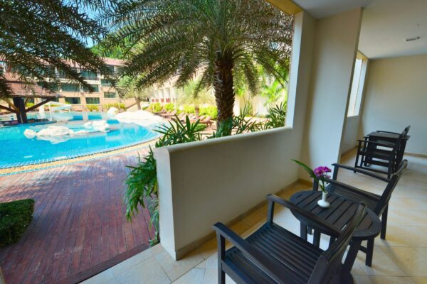 Nyd udsigten fra et resorts balkon med udsigt til swimmingpool omringet af palmetræer