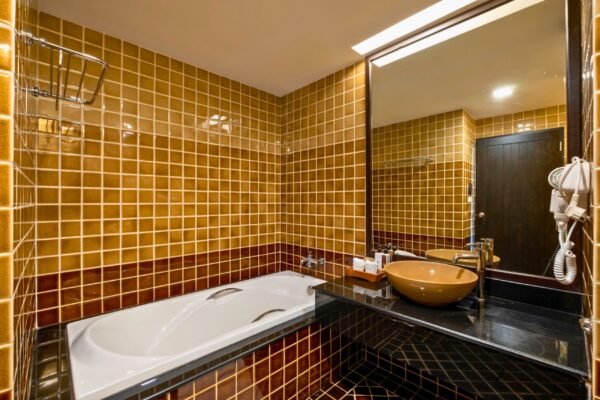 Kacha Resort badeværelse med gule flisevægge og badekar