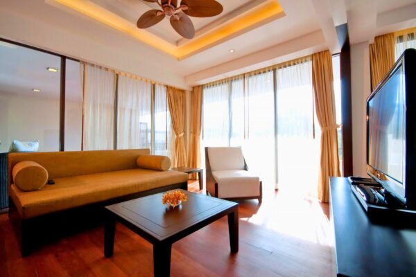 en stue med loftsventilator og sofa i Kacha Resort. Billedet har et komfortabelt møbleret loungeområde med moderne loftventilatordesign på