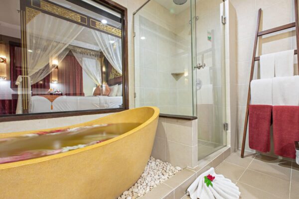 Se billedet af det spa-inspirerede badeværelse med badekar og håndklæder på Kata Palm Resort. Et ideelt sted for wellness og afslapning.