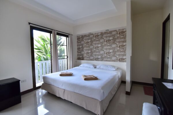 Koh Hai Fantasy Resort soveværelse billede med en hvid seng og vindue. resort indkvartering i Thailand med ren, minimalistisk stil værelse