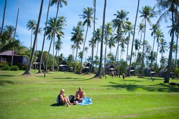 To personer slapper af på græsset på Koh Kood Beach Resort Thailand