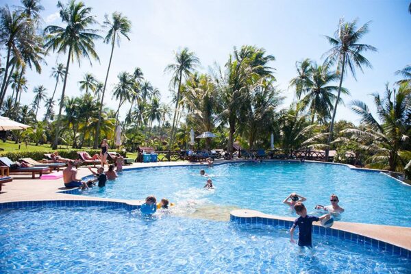 Koh Kood Beach Resort swimmingpool med folk, der nyder rekreative aktiviteter.