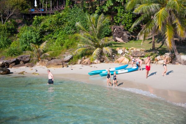 Koh Kood beach resort, gruppe mennesker slapper af, solskinsdag på stranden, ferie i Thailand