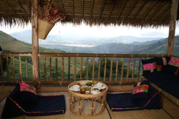 Afsondret balkon med bord og stole med udsigt over de smukke landskaber på Lanjia Lodge, Chang Rai. Ideelt sted for et fredeligt måltid
