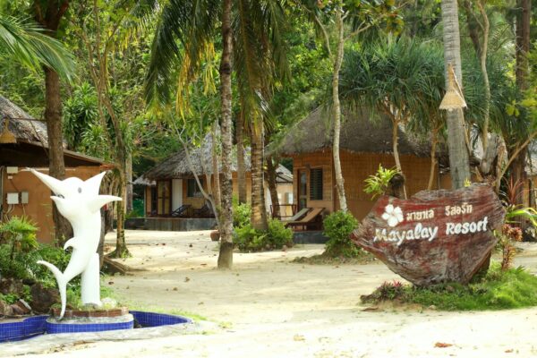 Indgang til Mayalay Beach Resort med traditionelle hytter og en ikonisk statue