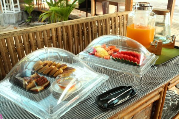 Træbord på strand resort med morgenmadsbuffet sammen med frugt og juice