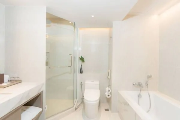 Hvidt moderne badeværelse med glasbrusestald på Pathumwan Princess Hotel