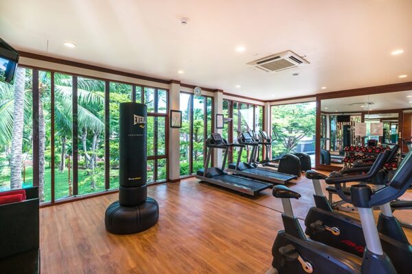 Boksegymnastik med store vinduer i Samui resort, udstyret med moderne boksemaskiner til træning. Ideel til fitnessentusiaster, der leder