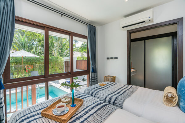 Pladsrigt soveværelse med senge og altan ved Peace Resort Samui, udsigt til swimmingpool
