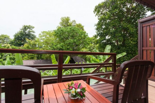 Træbalkon i Phi Phi hus med bord og stole med udsigt til naturligt feriested