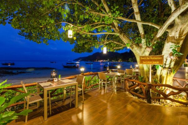 Restaurant ved stranden på Phi Phi Natural Resort med udendørs siddepladser på stranden om natten
