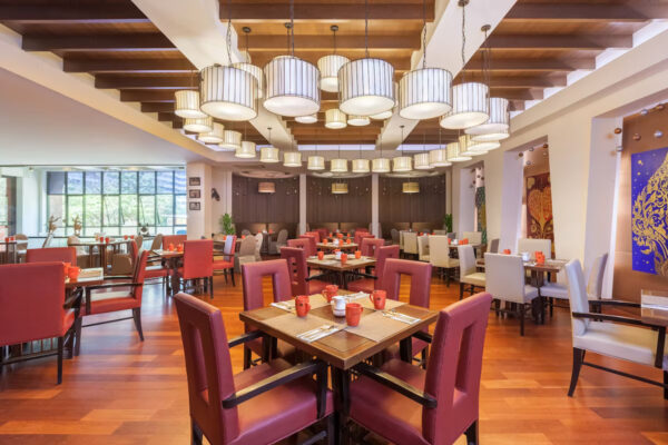 Hotel med røde stole og træborde i Bangkok: Rembrandt Hotel og Suites. Perfekt til forretningsmøder, romantiske middage eller afslappende