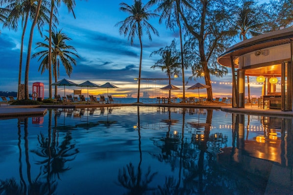Slap af på SAii Laguna Phuket Resort med pool og liggestole ved skumring